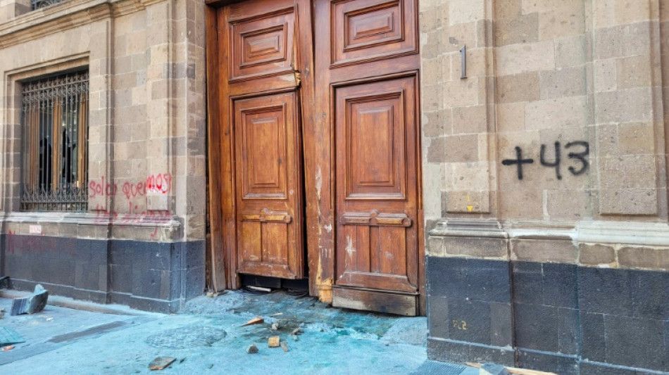 Manifestantes de Ayotzinapa derrubam a porta do pal&aacute;cio presidencial no M&eacute;xico