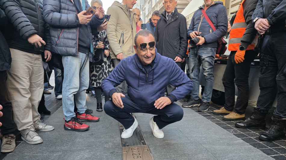 Carlo Conti posa a Sanremo una targa per Olly