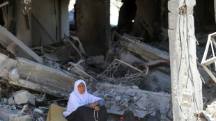 Palestinos que retornam ao campo de refugiados de Gaza caminham em meio a ru&iacute;nas